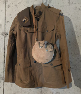 A close-up of a vintage military jacket with authentic patches and worn fabric.