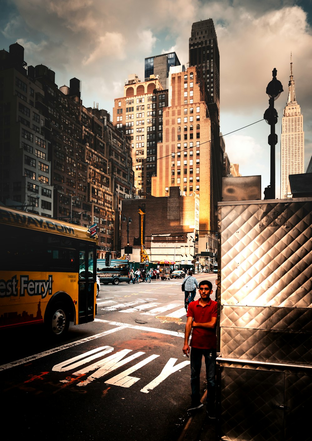 man in red jacket standing on pedestrian lane during daytime