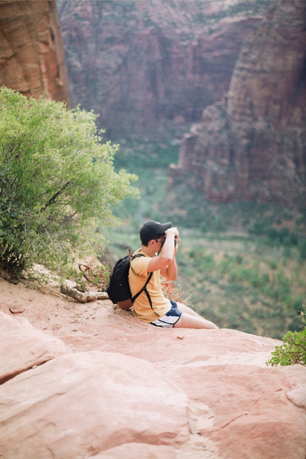 woman in black and white stripe tank top sitting on brown rock during daytime