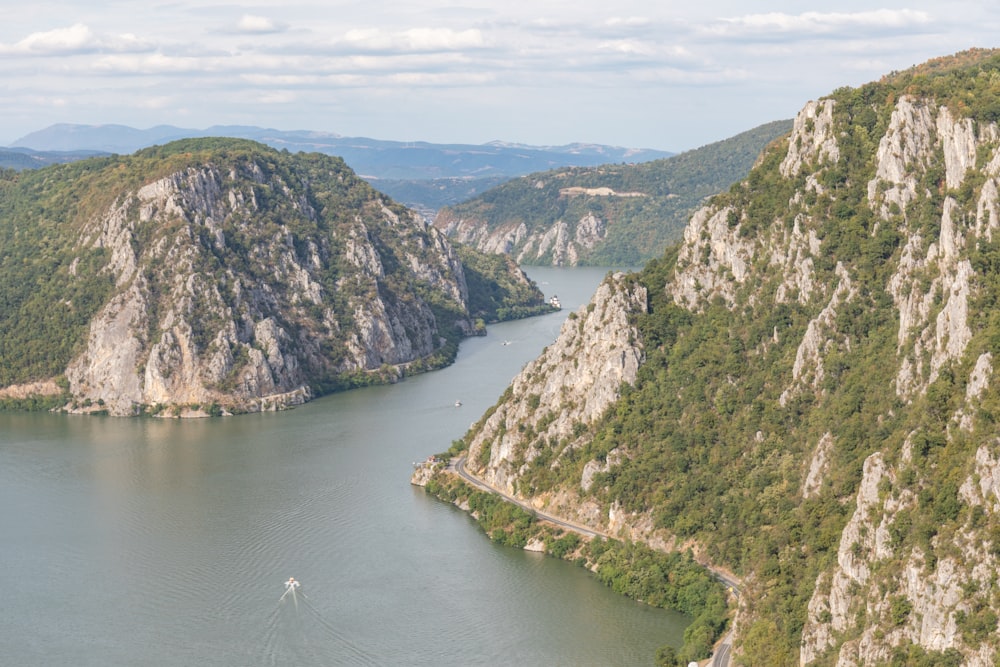 green and brown mountain beside river during daytime