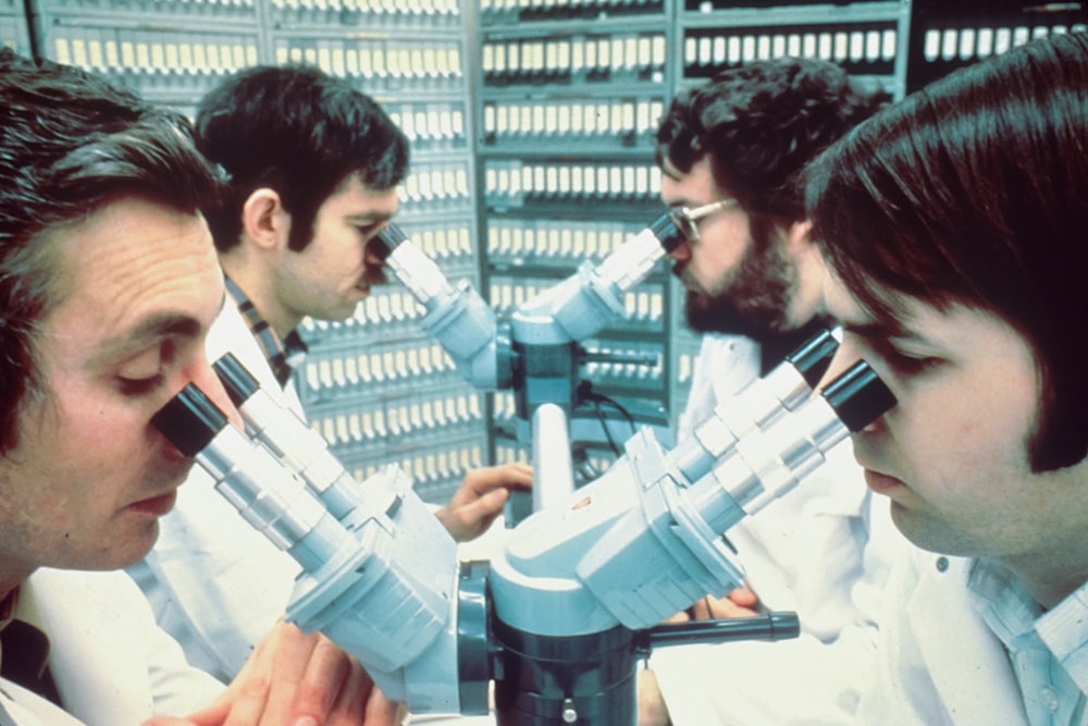 2 men in white and blue uniform holding blue and white plastic toy