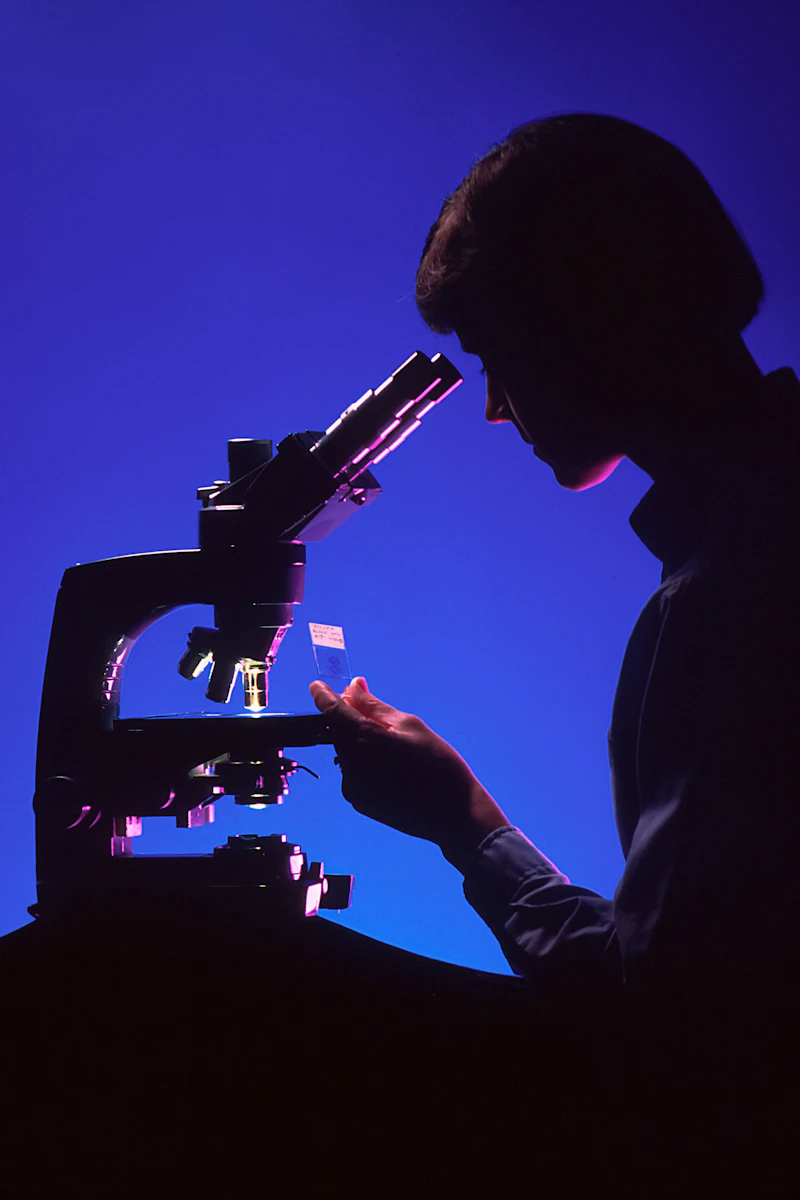 Silhouette of a person at a microscope