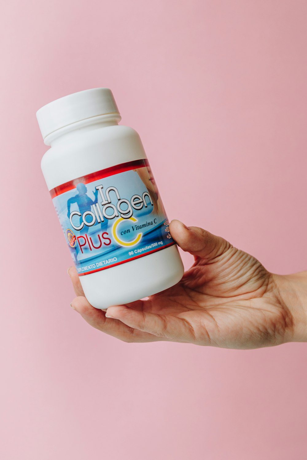 person holding white and blue plastic bottle