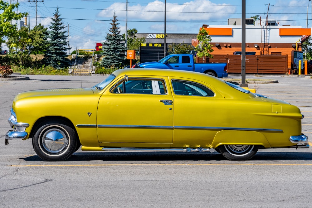 yellow classic car parked on gray concrete road during daytime