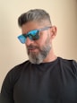 man in black crew neck shirt wearing blue sunglasses
