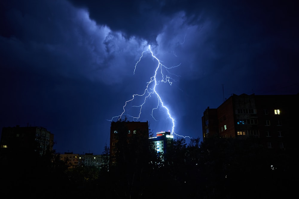 a lightning bolt strikes over a city at night