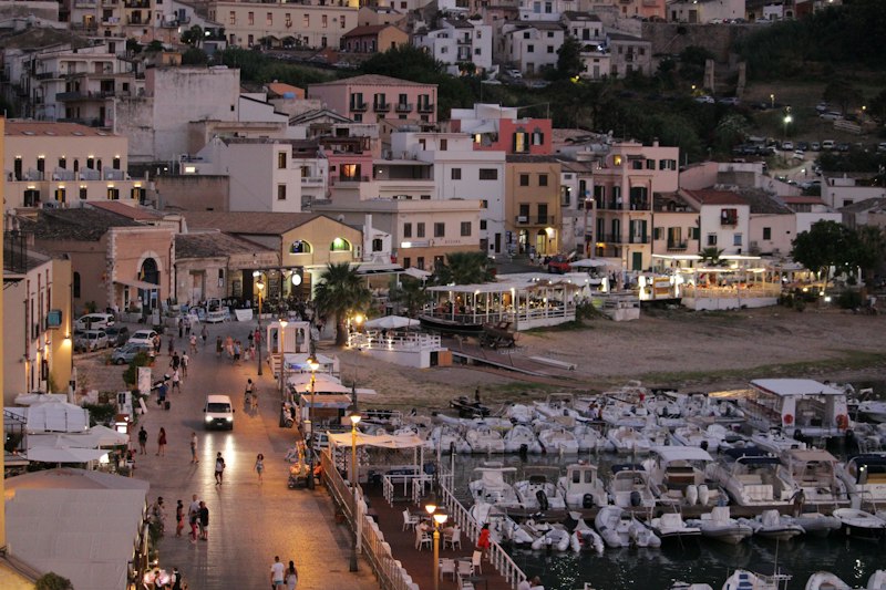 Boats moored in Castellammare del Golfo's harbor at dusk