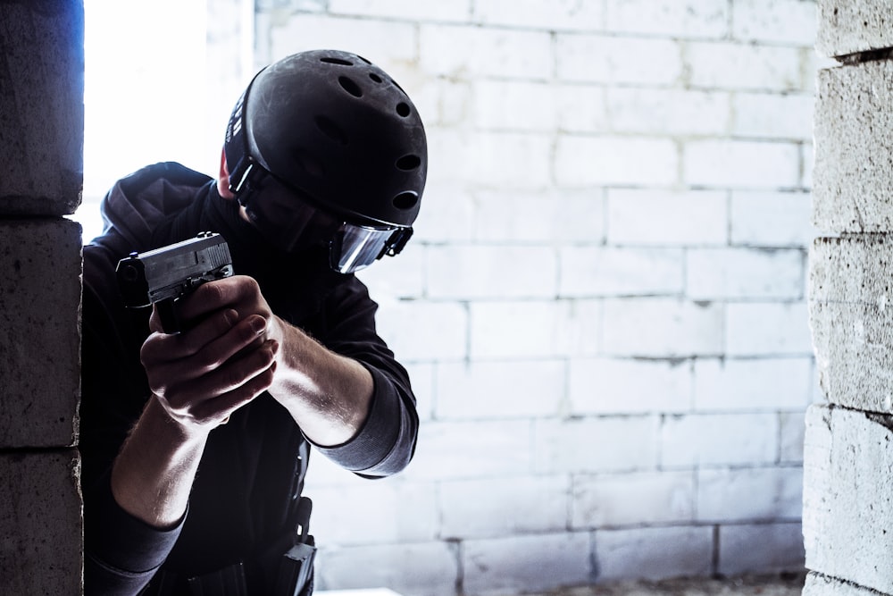 man in black helmet holding black smartphone