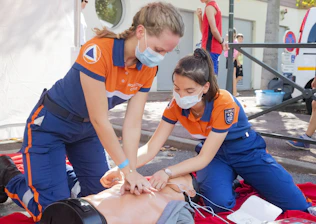 Nurses engaged in a hands-on emergency training session with medical equipment.