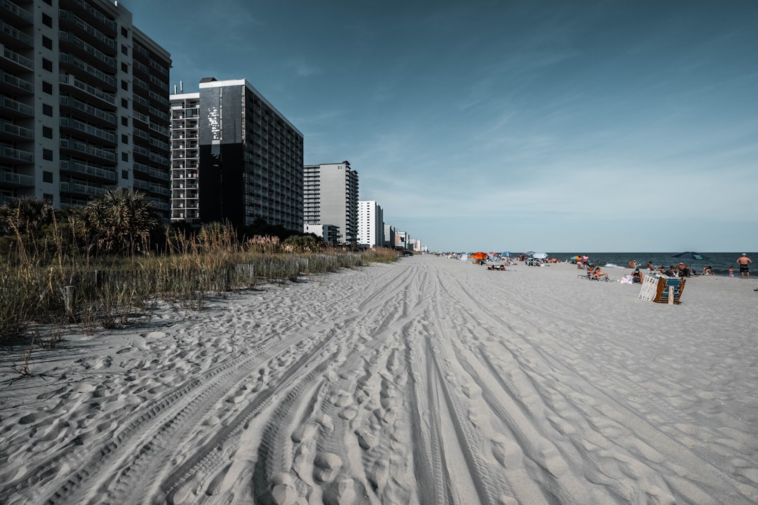 white sand beach near city buildings during daytime