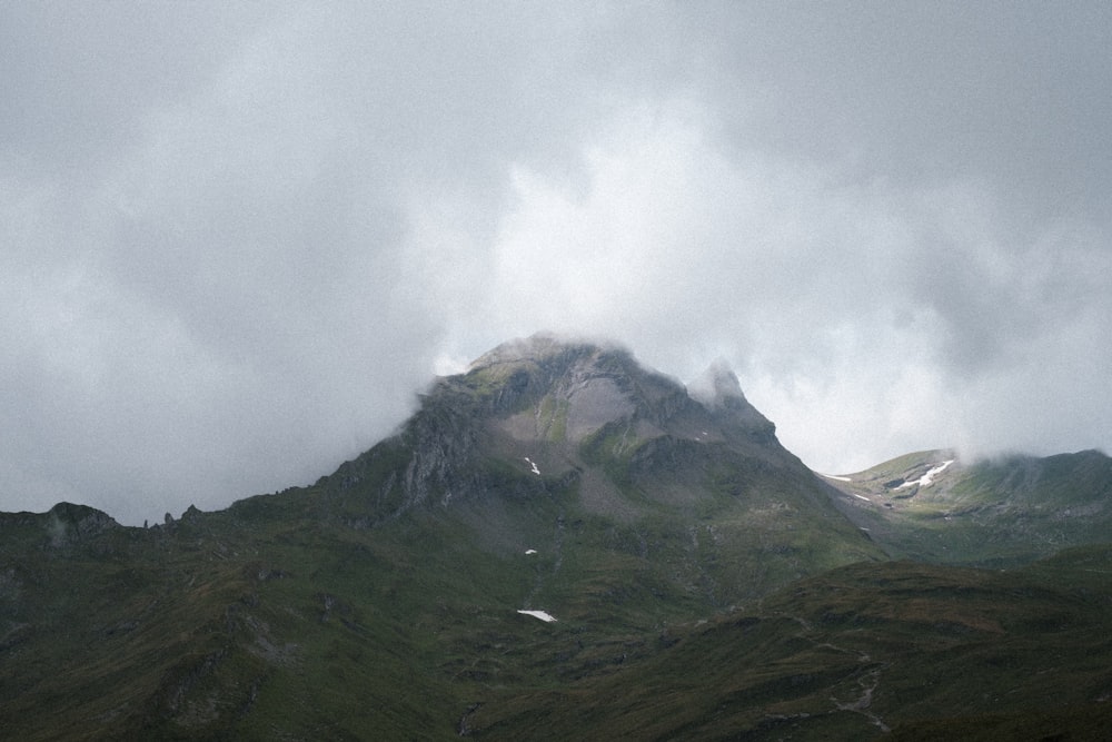 grüner und brauner Berg tagsüber unter weißen Wolken