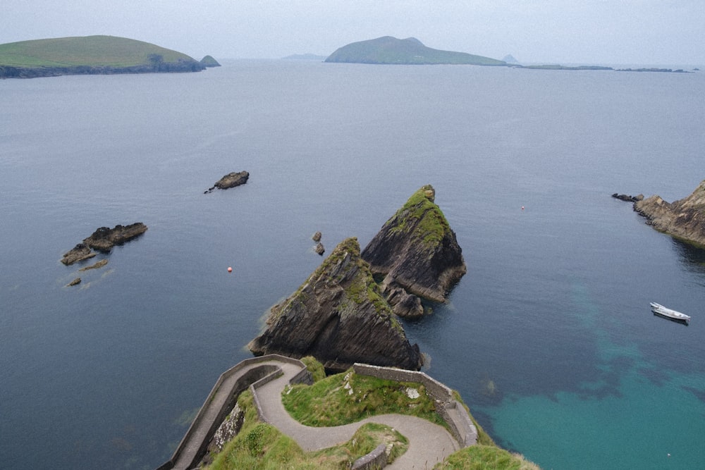 green and brown rock formation on body of water during daytime