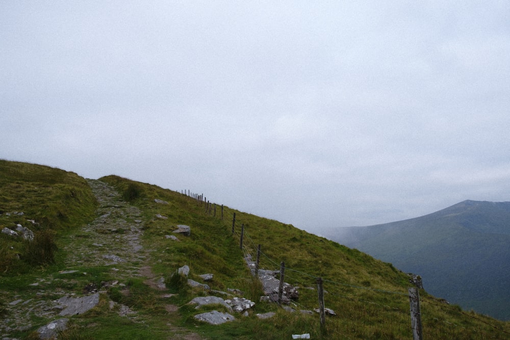 green grass covered mountain under white sky during daytime