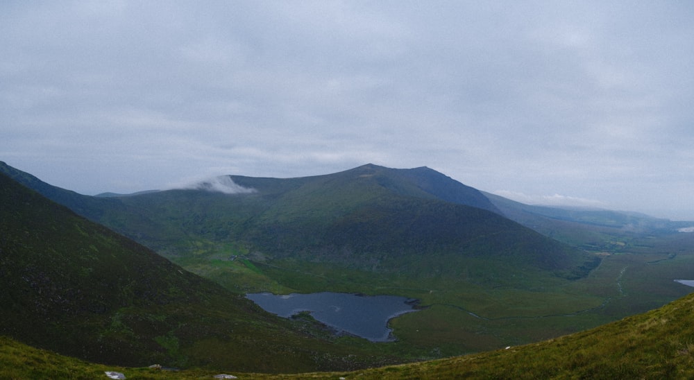 green mountain near body of water during daytime