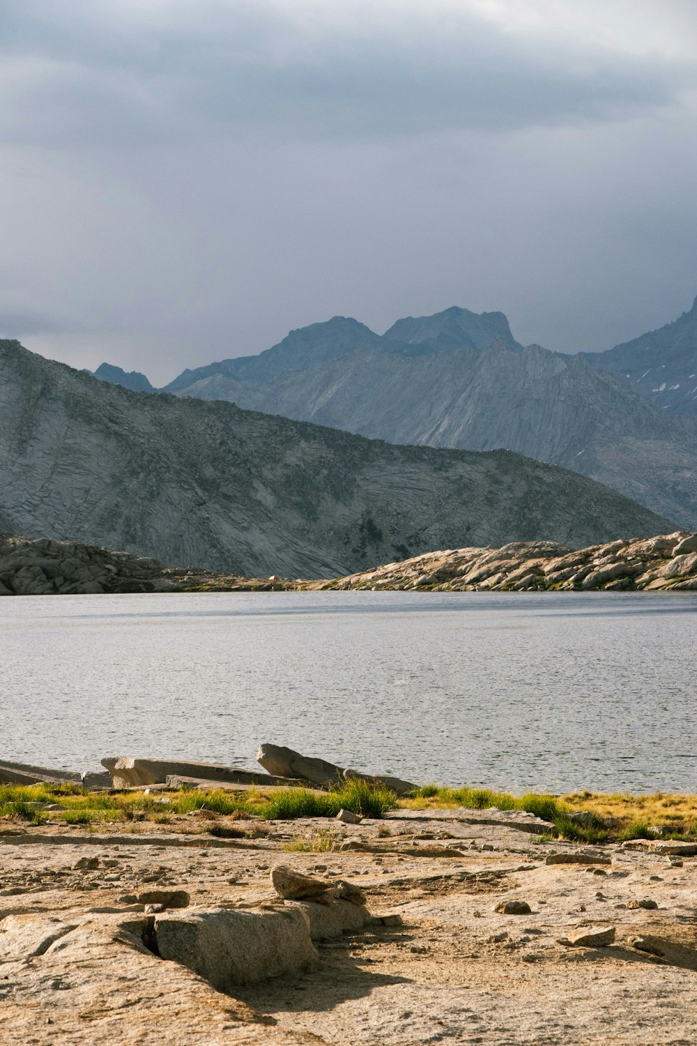 body of water near mountain during daytime