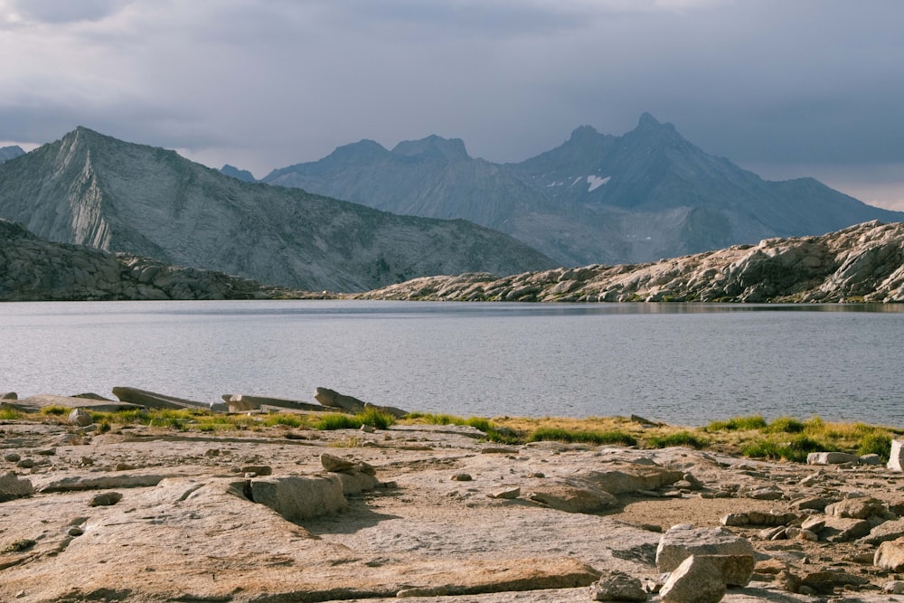 body of water near mountain during daytime