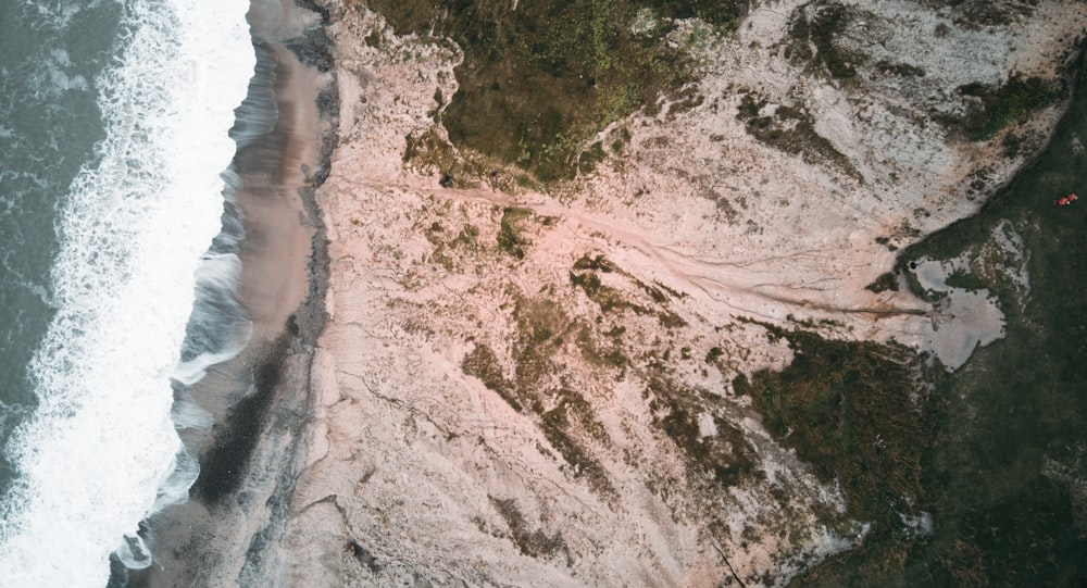 white and brown sand near body of water during daytime