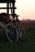 black commuter bike near brown wooden fence during sunset