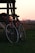 black commuter bike near brown wooden fence during sunset