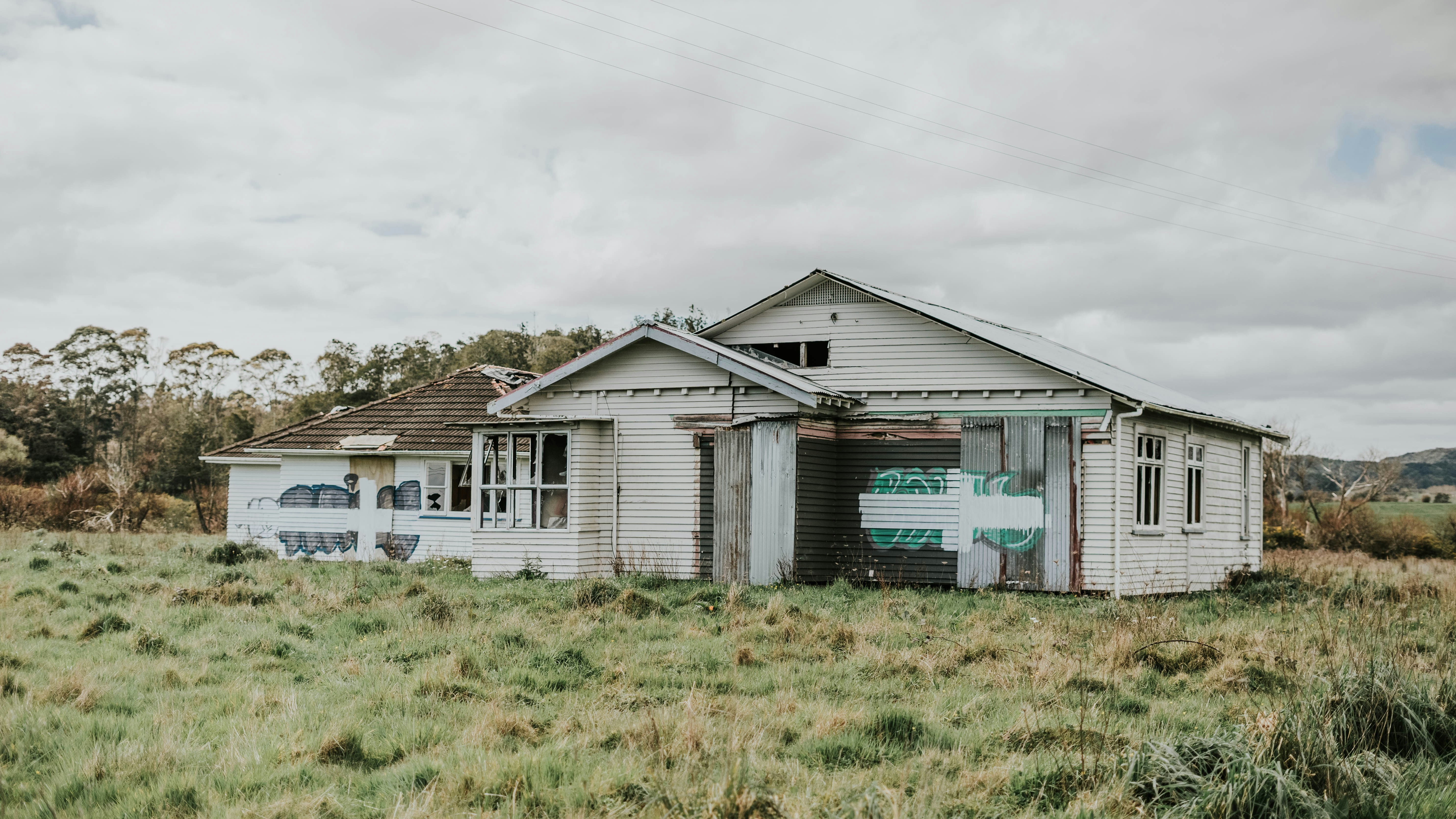 blue and white wooden house on green grass field under white cloudy sky during daytime