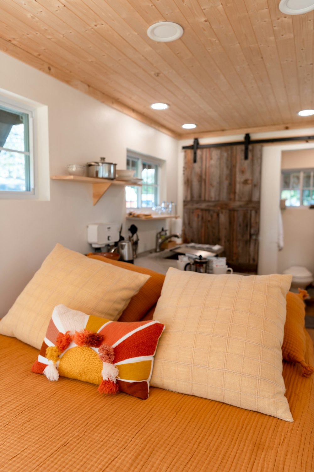 orange and white throw pillows on brown couch