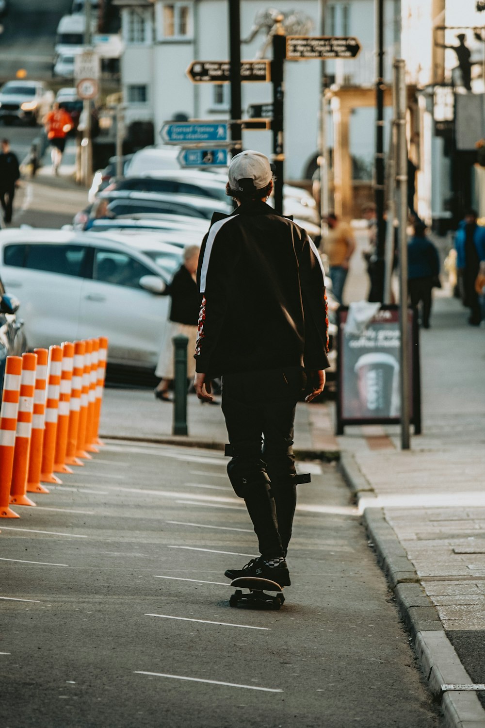 homme en veste noire marchant sur le trottoir pendant la journée