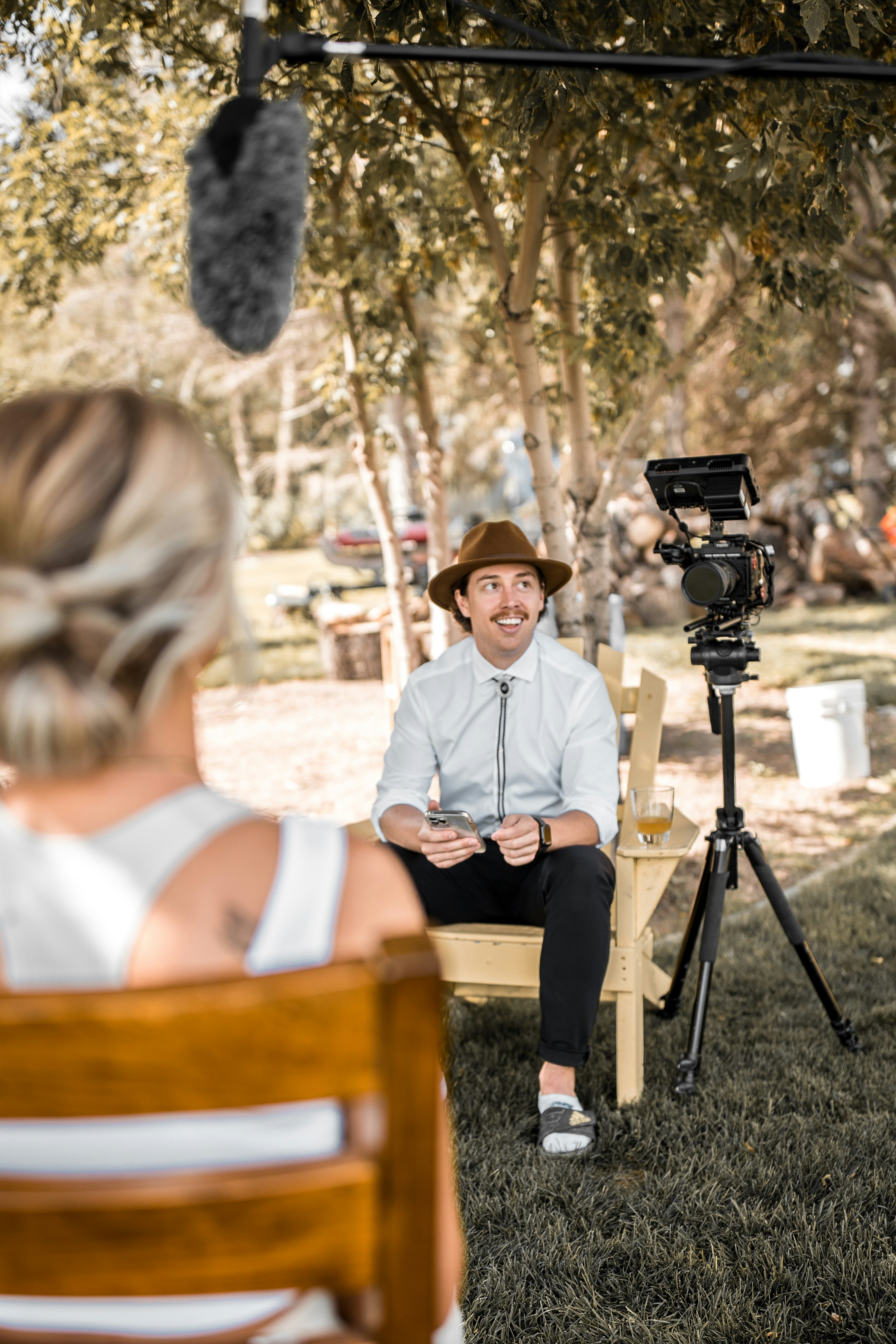 2 women sitting on brown wooden bench during daytime