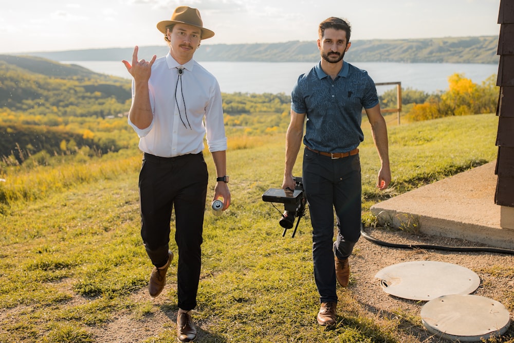 man in blue polo shirt and black pants standing beside man in white dress shirt