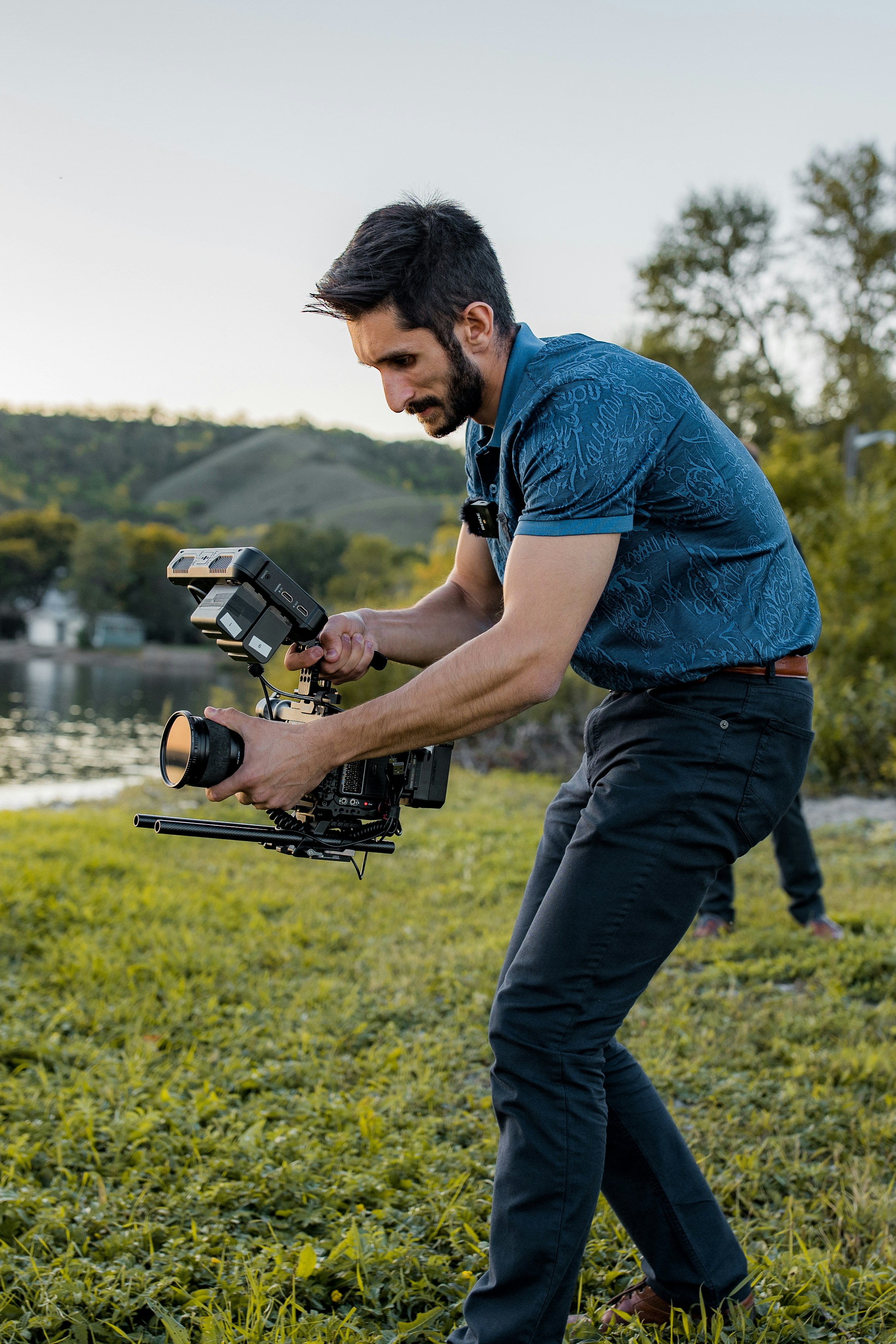 man in blue polo shirt and blue denim jeans holding black and gray power tool