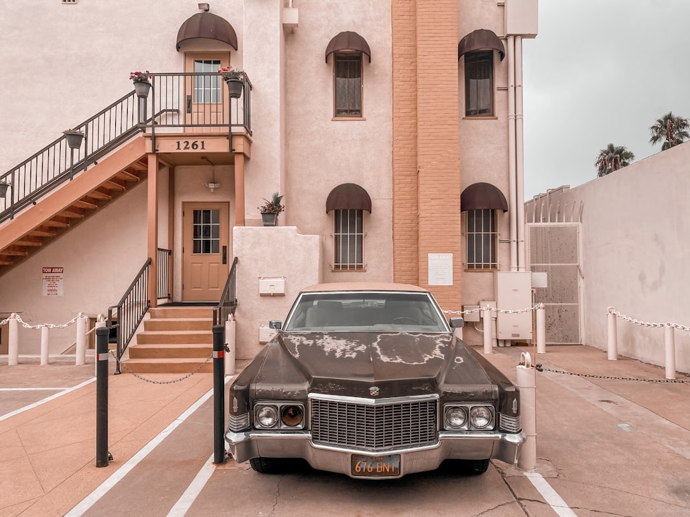 Voiture noire garée à côté d’un bâtiment brun