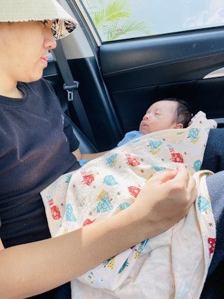 A driver assisting a family with baby seats into the vehicle.