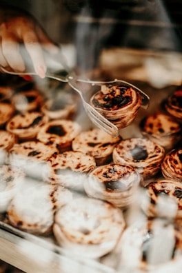 A vendor in a cozy kitchen pulling a freshly baked fruit tart from the oven.