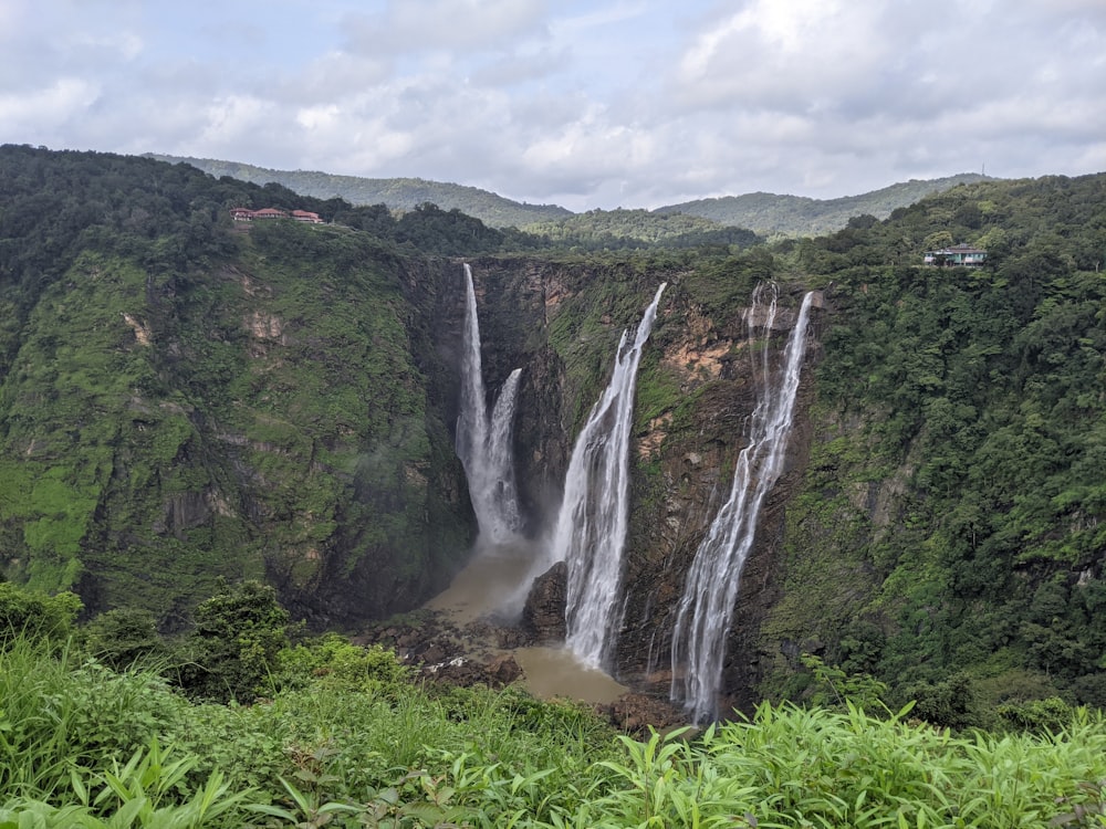 waterfalls in the middle of green grass field