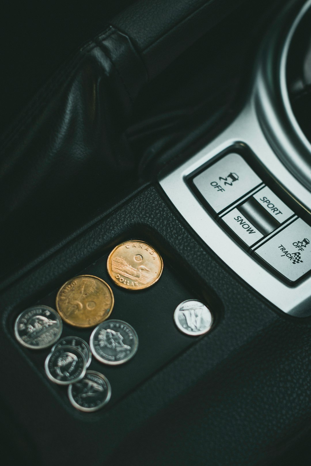 silver round coins on black car center console