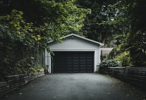 gray wooden house near green trees during daytime