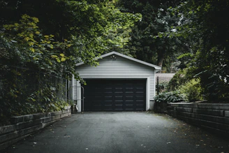 gray wooden house near green trees during daytime