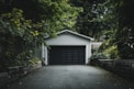 gray wooden house near green trees during daytime