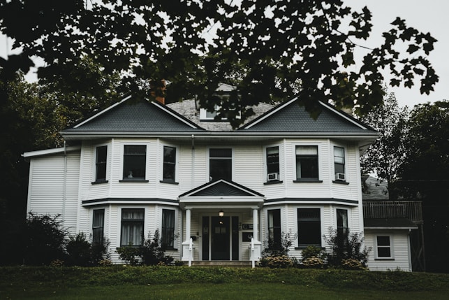white and gray house near green grass field during daytime