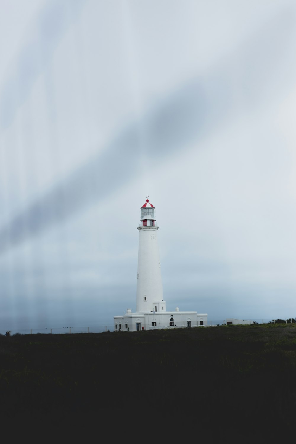 Weißer und roter Leuchtturm in der Nähe des Gewässers