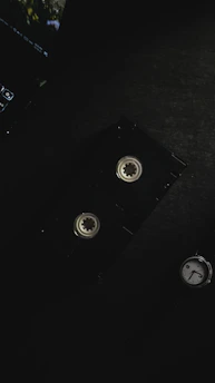 A vintage VHS tape resting on a wooden table with soft film reels in the background, evoking nostalgia.