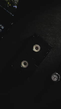 A vintage VHS tape with a worn label resting on a wooden table, bathed in soft warm light