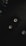 A vintage video cassette is placed on a dark surface, alongside part of a laptop keyboard in the top left corner and a watch in the bottom right. The lighting is dim and creates a moody atmosphere.