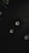 A vintage video cassette is placed on a dark surface, alongside part of a laptop keyboard in the top left corner and a watch in the bottom right. The lighting is dim and creates a moody atmosphere.
