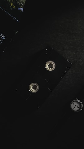 Close-up of a vintage VHS tape being inserted into a modern video converter device.