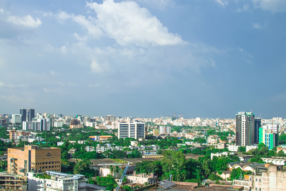 city buildings under white clouds and blue sky during daytime