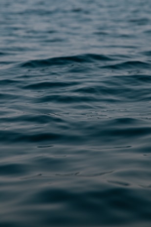 Calm ripples of water under soft, muted lighting, creating a serene and reflective surface.