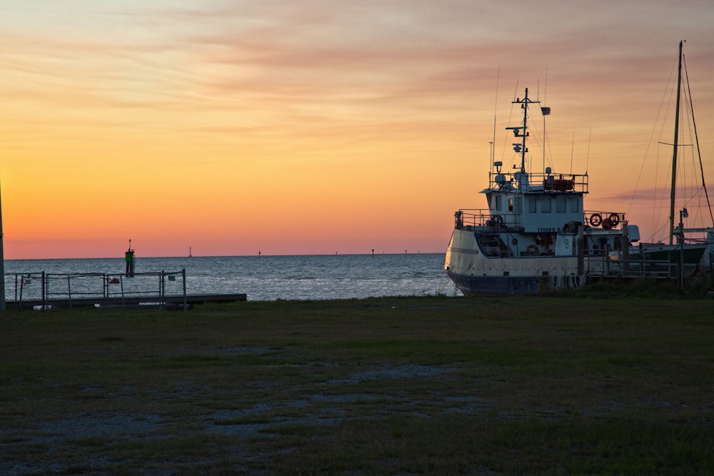 white boat on sea during sunset