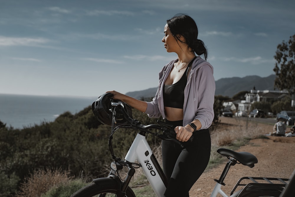 woman in white shirt riding on black bicycle during daytime