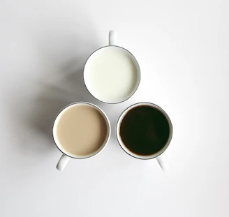 Three puzzle mugs arranged side by side revealing parts of a larger abstract image.
