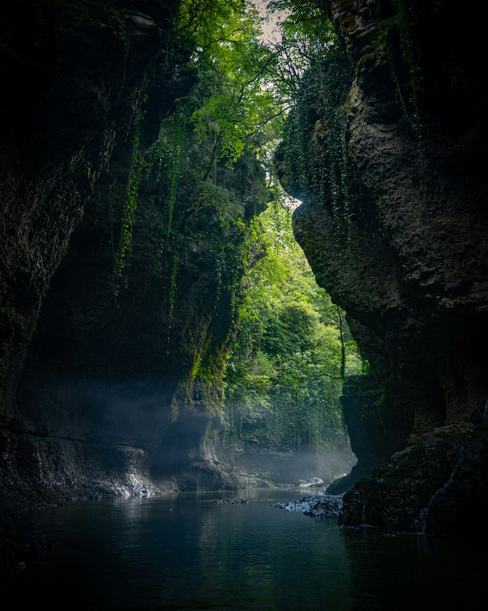 water falls between green moss covered rocks